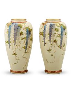 two white vases with designs on them sitting side by side in front of each other