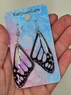 "Clear acrylic butterfly wing earrings with black details and a resin topcoat. Approximately 2 inches long, 1 inch wide, and 1/8\" inch thick.  Do not clean your earrings with alcohol or acetone, as this may cause micro cracks to form.  Hardware options include: -Stud (adds a circular acrylic bit that matches the outline color of the earrings) -Silver ear wire -Silver Clip On -Silver Kidney Wire 47mm (perfect for stretched ears or low dangles) Please note that shipping time may vary between 3 bu Fictional Dresses, Butterfly Wings Earrings, Kei Jewelry, Iridescent Butterfly, Cottagecore Earrings, Acrylic Butterfly, Wings Earrings, Diy Earrings Polymer Clay, Earrings Butterfly