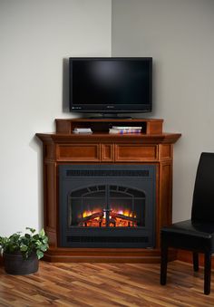 a fireplace with a flat screen tv above it and a chair in front of it