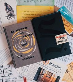 a book sitting on top of a pile of paper next to other books and papers