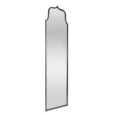 a tall mirror sitting on top of a white wall