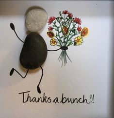 there is a rock with flowers on it and the word thanks written in black ink