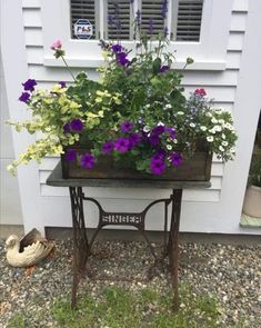 a small table with flowers in it sitting outside