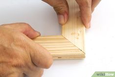 a person is working on a piece of wood with one hand and the other hand