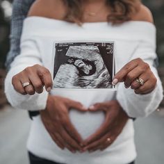 a woman holding her stomach in the shape of a heart