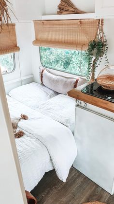 a bed in a small room next to a window with bamboo shades on the windowsill