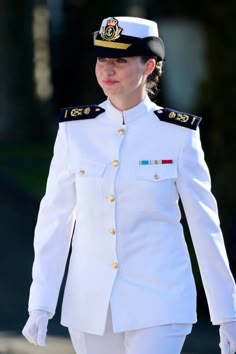 a woman in uniform walking down the street