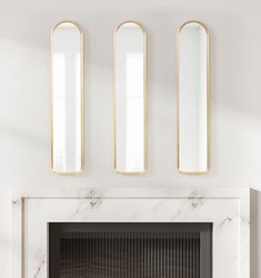 a fireplace with three mirrors above it