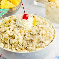 a white bowl filled with rice and topped with a cherry