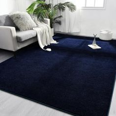 a living room with a white couch and blue rug