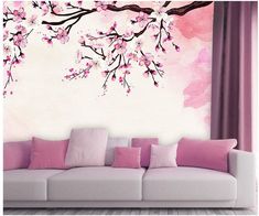 a living room with pink flowers on the wall and white couch in front of it