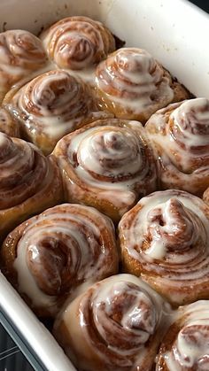 a pan filled with cinnamon rolls covered in icing