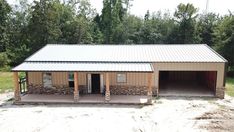 a two car garage sitting in the middle of a dirt lot next to some trees