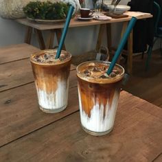 two drinks sitting on top of a wooden table