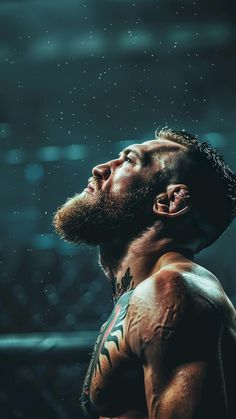 a man with tattoos on his chest looking up at the sky while standing under rain