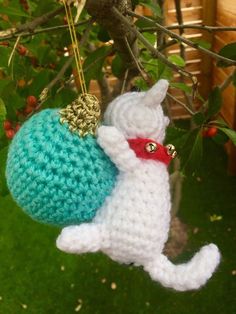 a crocheted cat ornament hanging from a tree