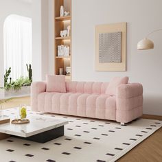 a living room with a pink couch and coffee table in the middle of the room