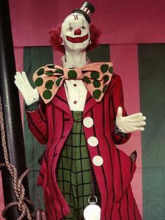 a creepy clown dressed in red and green