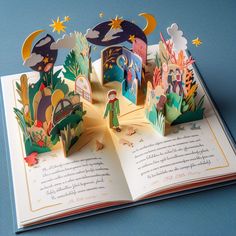 an open book with paper cut out of the pages and children's illustrations on it