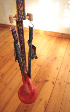 a pair of scissors hanging from a hook on a wooden floor