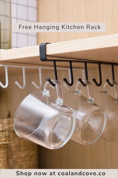 coffee mugs are hanging on the wall in this kitchen rack with hooks and cups