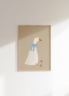 a white duck with a blue bow on it's head hanging from a wall