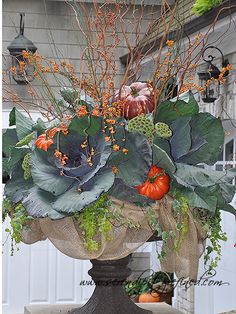 a vase filled with lots of different types of flowers and greenery on top of a table