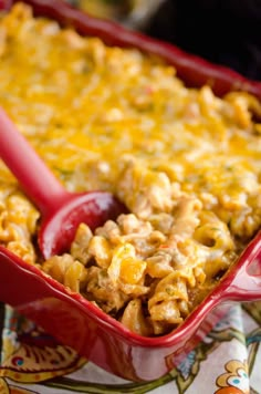 a red casserole dish filled with macaroni and cheese