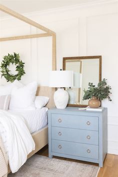 a bedroom with a bed, dresser and mirror on the side table in front of it