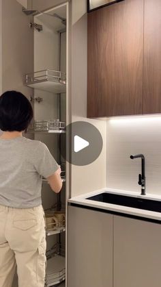 a woman standing in front of a kitchen sink