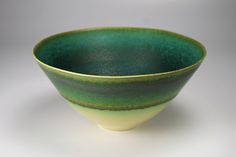 a green and yellow bowl sitting on top of a table