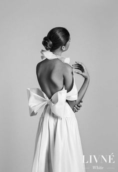 the back of a woman's dress with a large bow at the neckline