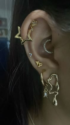 an ear with three different types of piercings on it's side and one is in the shape of a star