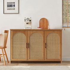 a wooden cabinet sitting in the corner of a living room next to a table and chair