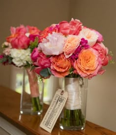 two vases with flowers are sitting on a mantle in front of a mirror and price tag