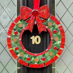 a red and green wreath with the number ten hanging on it's front door