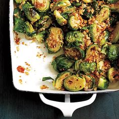 brussel sprouts and other vegetables are in a white casserole dish