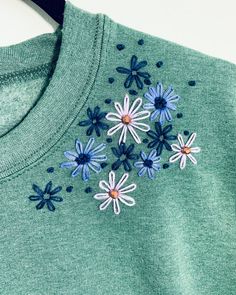 a green shirt with blue and white flowers on it