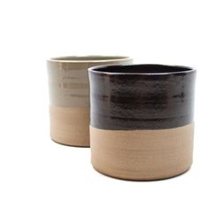 two black and tan cups sitting next to each other