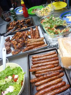 hot dogs, salad and other foods are on the table