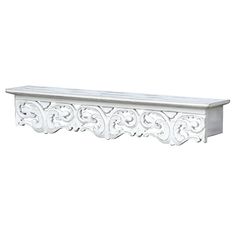 a white shelf with ornate carvings on the top and bottom, against a white background