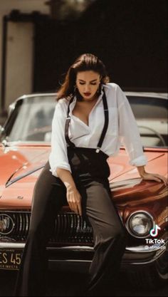 a woman sitting on the hood of a car