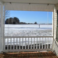 the porch is covered with snow and ice as it sits in front of a lake