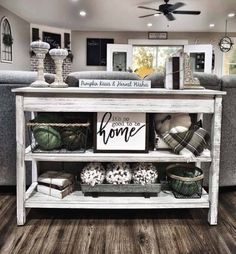 a living room filled with furniture and decor on top of a wooden floor next to a couch