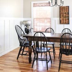 a dining room table with six chairs and a chandelier hanging from the ceiling