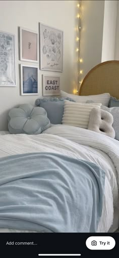 a bed with blue sheets and pillows in a bedroom next to pictures on the wall