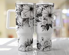 two coffee mugs with floral designs on them