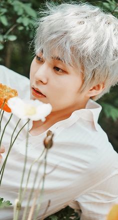 a man with white hair holding flowers in his hand