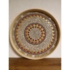 a decorative glass plate sitting on top of a wooden shelf