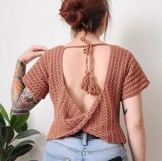 the back of a woman's top with tassels on her neck and shoulders